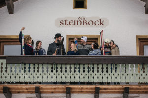Skifahrer auf dem Balkon der Pension