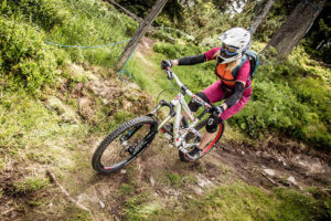 Mountainbikerin fährt auf einem Waldweg